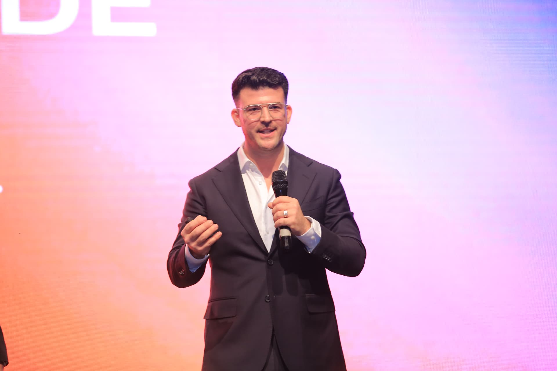 Eric Smith hält einen Vortrag auf einer Bühne vor einer LED-Leinwand